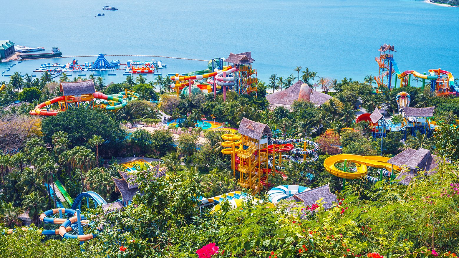 aquapark with slides at the resort in entertainment park in summer. Amusement park with waterpark by sea on VinPearl Island in Nha Trang in Vietnam aerial top view
